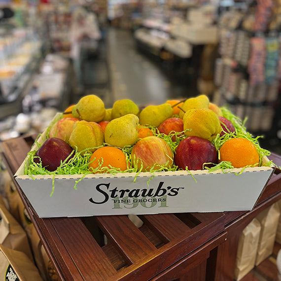 Fruit basket with apples, pears, and oranges in a Straub's Fine Grocers box in a grocery store.