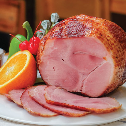 Sliced ham on a plate with an orange and decorative elements
