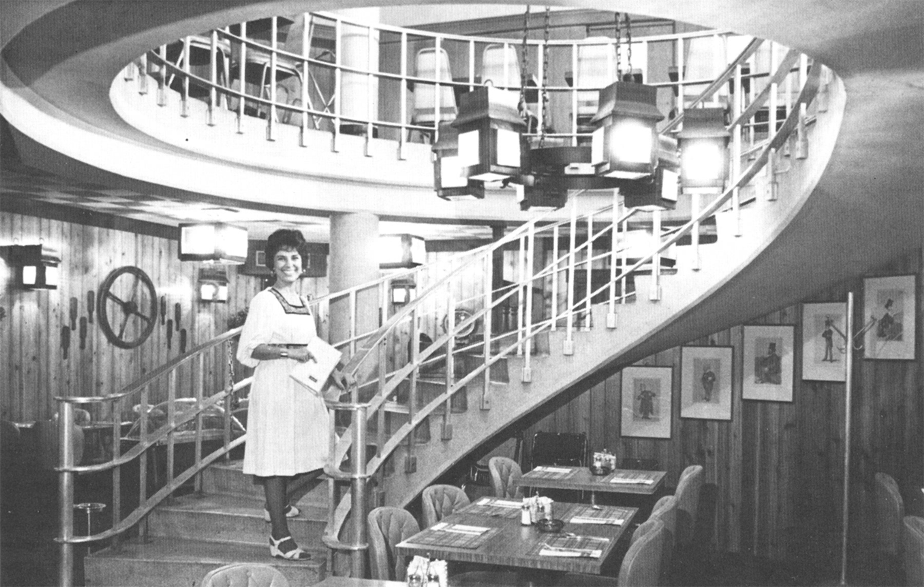 Woman standing on a spiral staircase in a restaurant interior