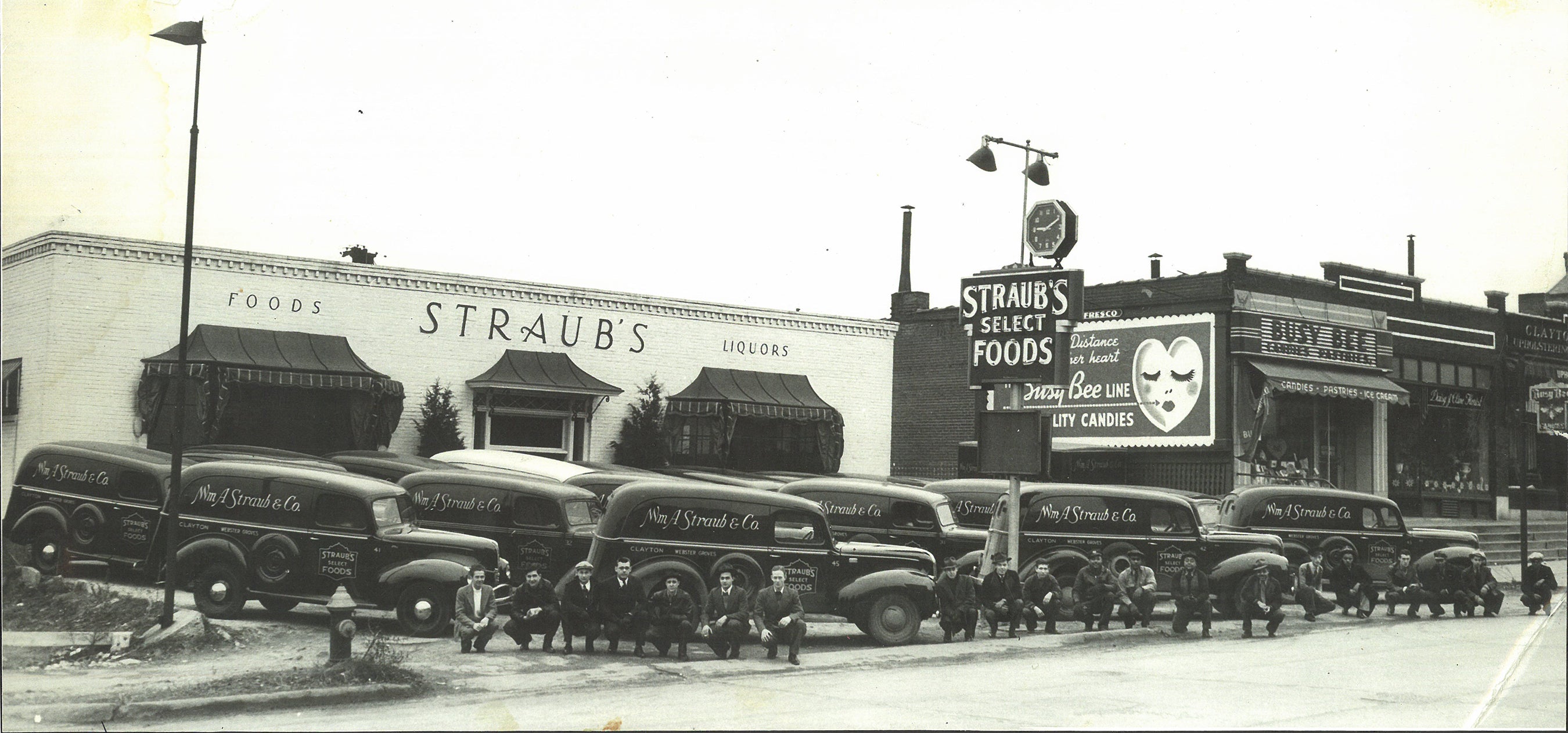 Vintage black and white photo of Straubs Foods store with delivery trucks in front